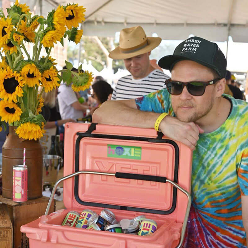 Josh Rosenstein founder of HOXIE standing next to a cooler with cans of HOXIE Wine Spritzer
