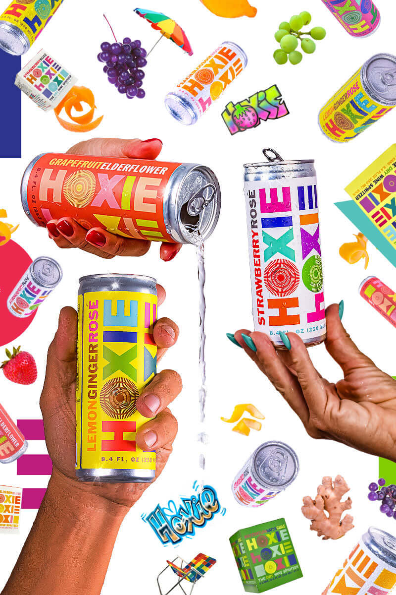 Cans of HOXIE Dry Wine Spritzer in hands with colorful art in the background