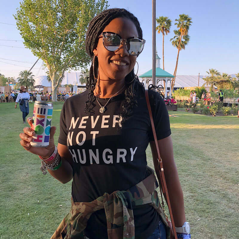 A woman at a music festival holding a can HOXIE Strawberry Rose Wine Spritzer